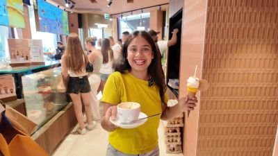 Traveler Jyoti holding a cappuccino and a gelato cone at Cioccolati Italiani in Milan