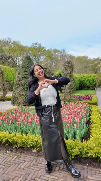 Traveler Jyoti making a heart sign among the tulips at Keukenhof, Netherlands