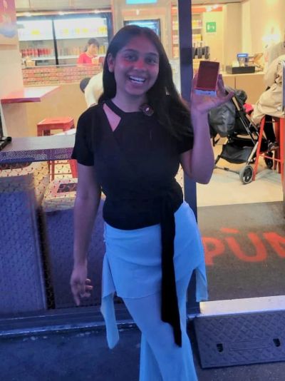 Traveler Jyoti holding a takeaway cup of tiramisù from Spun in Milan