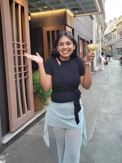Traveler Jyoti holding a gelato cone on a street in Milan