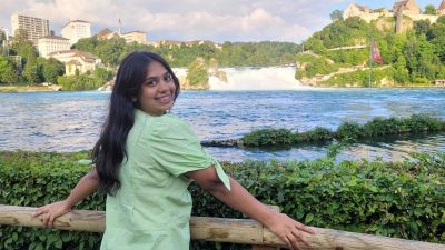 Traveler Jyoti at the free Rhine Falls viewpoint in Neuhausen with Schloss Laufen castle visible across the river