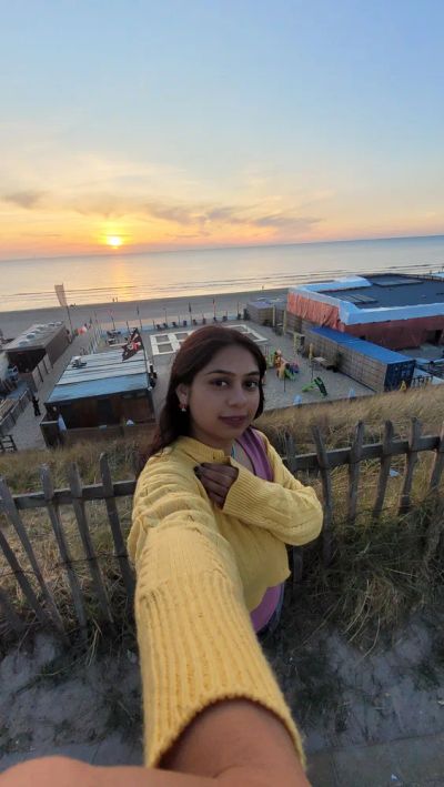 Traveler Jyoti watching the sunset over a North Sea beach in the Netherlands